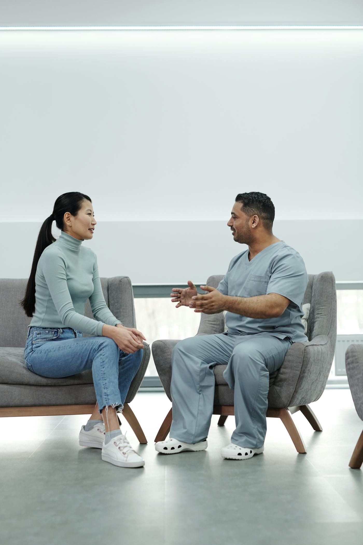 Profissional de saúde conversando com paciente em consultório.